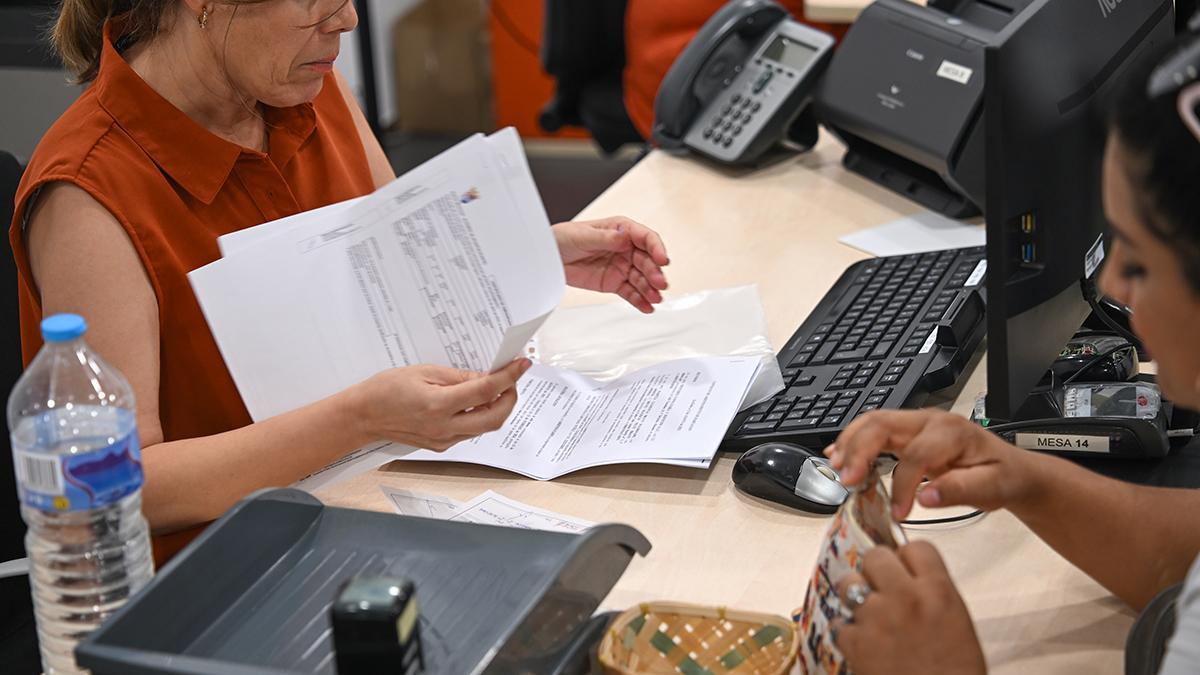 Una funcionaria realiza unos trámites en una administración de Elche