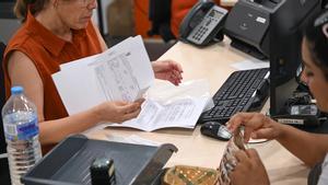 Una funcionaria realiza unos trámites en una administración de Elche