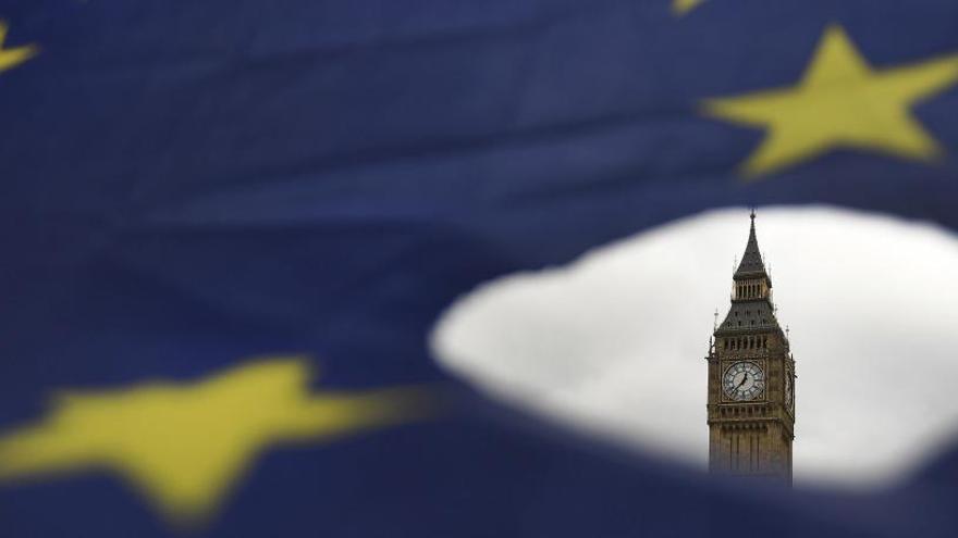 El Big Ben vis per un forat a la bandera de la UE, a Londres.