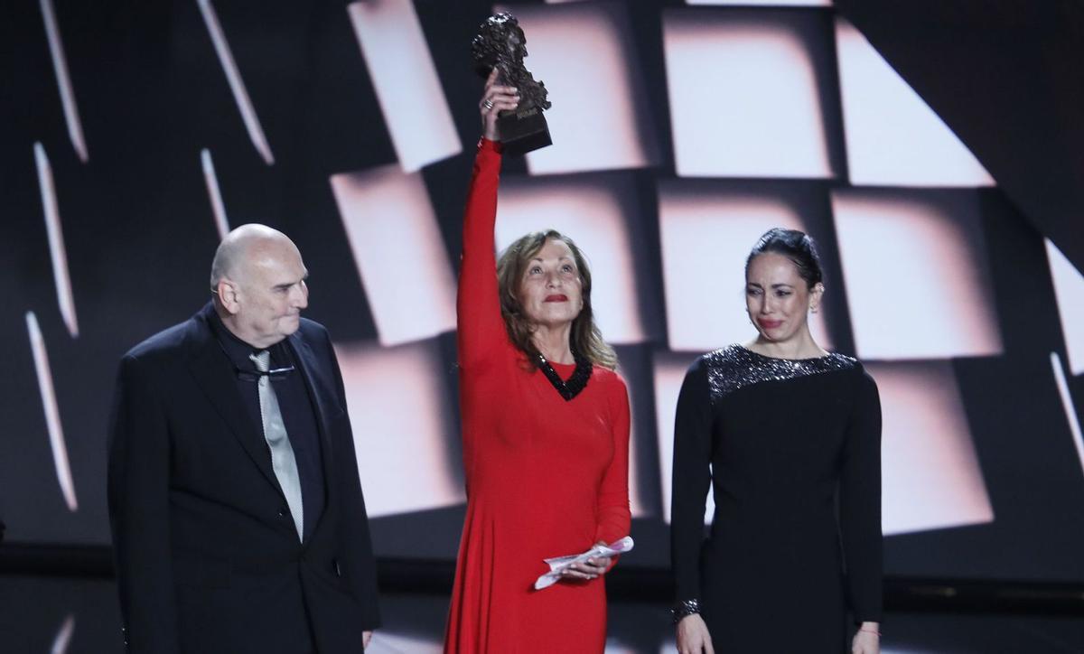 Eulalia Ramón (c), viuda de Carlos Saura, levanta el Goya de Honor en presencia de los hijos del director fallecido, Antonio (i) y Ana (d). | | JOSÉ MANUEL VIDAL (EFE)