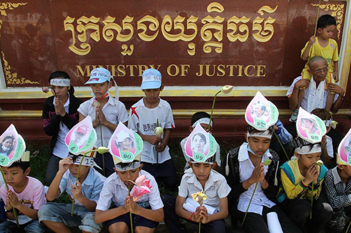 Un grup de nens amb retrats de les seves mares, detingudes durant una manifestació, resen durant una protesta davant el Ministeri de Justícia, a Phnom Penh (Cambodja).