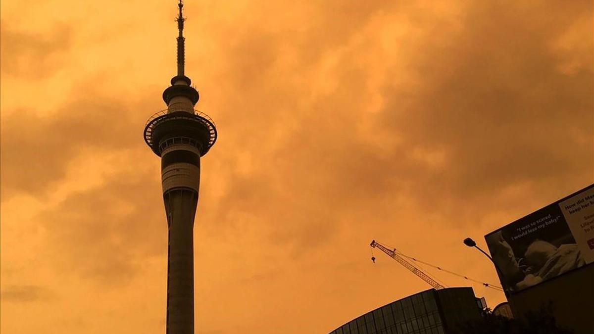 La silueta de la Sky Tower en Auckland (Nueva Zelanda) recortada contra un cielo naranja a causa del humo de los fuegos de Australia