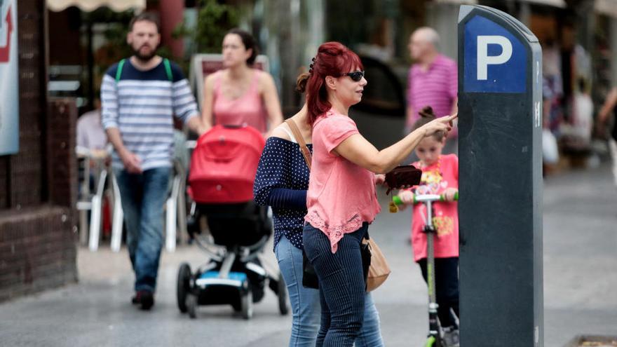 Una mujer abona su tarifa en un parquímetro de Benidorm