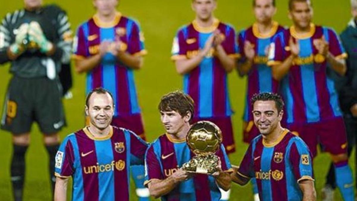 Iniesta y Xavi secundan a Messi con el trofeo en el Camp Nou.