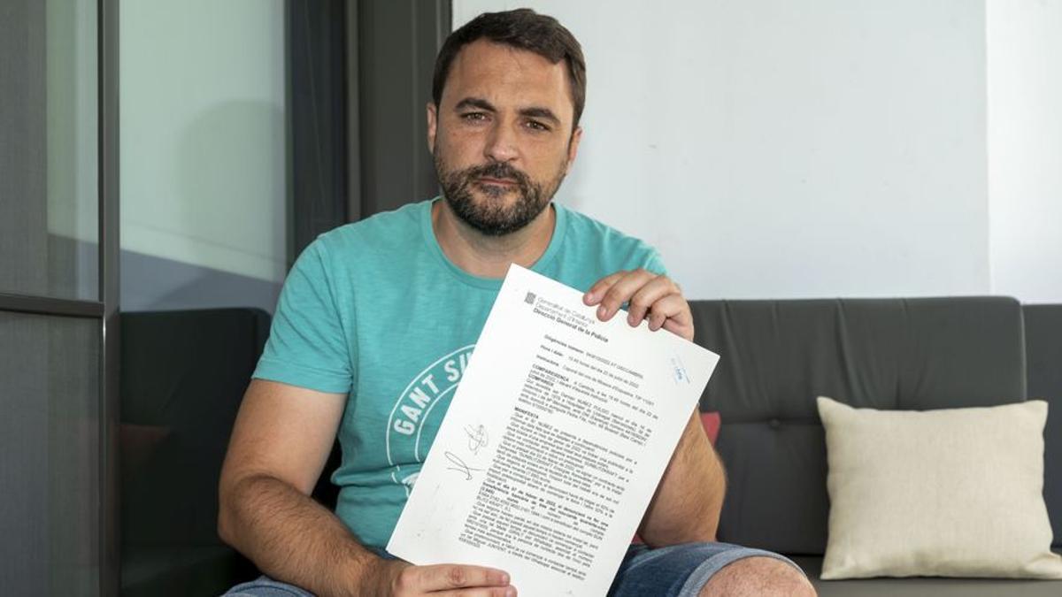 Damian Núñez sujeta la denuncia presentada a los Mossos sobre la estafa de la que fue víctima.