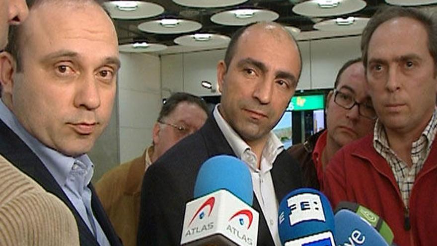 Los forenses turcos Bülent Sam (c) y Omer Müslümanoglu (i), a su llegada al aeropuerto madrileño de Barajas