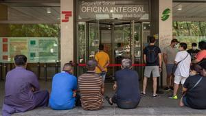 Colas ante una oficina de la Tesorería General de la Seguridad Social, en Barcelona.