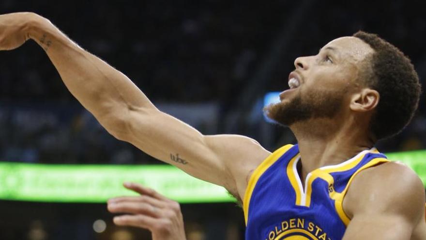 Stephen Curry lanza a canasta.