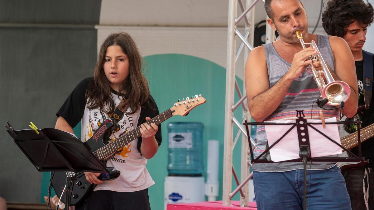 Alumnos de la Escuela Municipal de Educación Musical con una guitarra eléctrica y una trompeta.