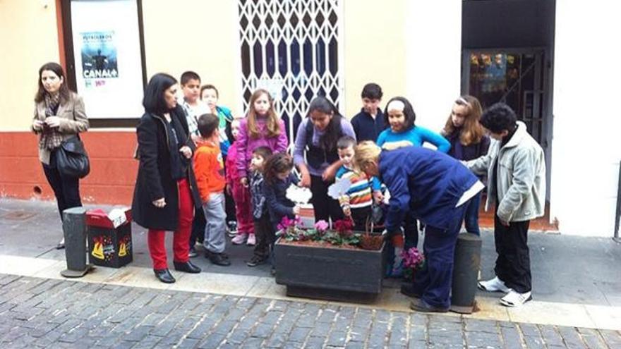 Un grupo de niños esperan este lunes la llegada de los Príncipes de Asturias.