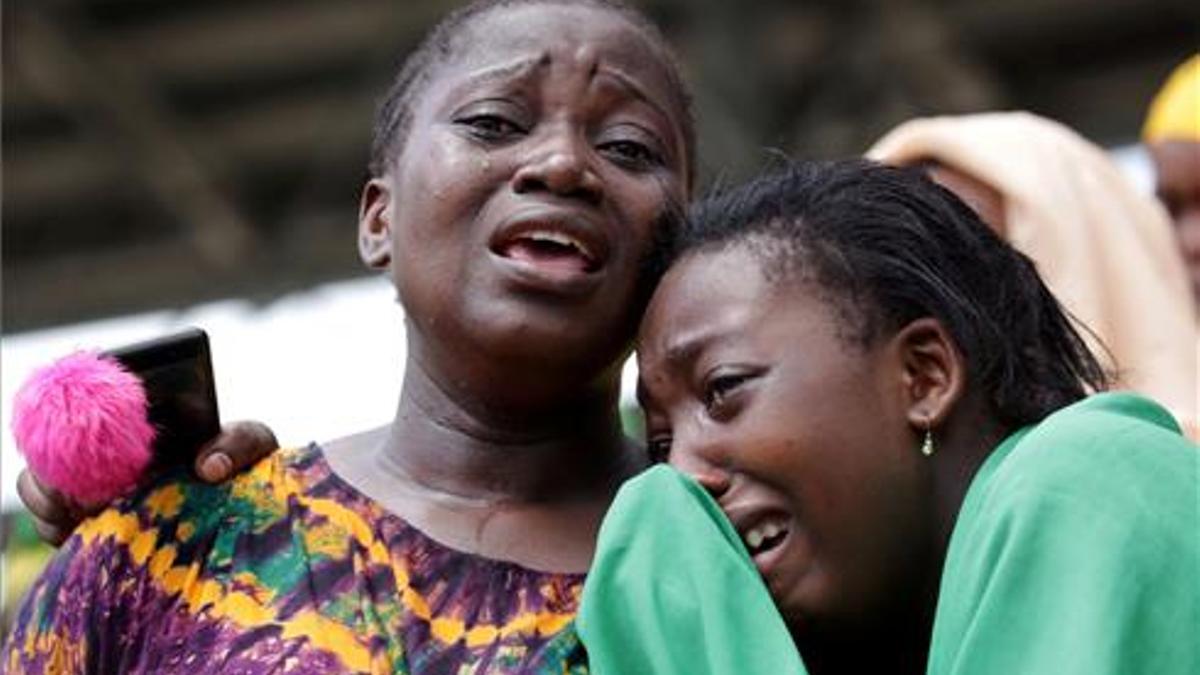 Civiles lloran al difunto presidente de Tanzania durante el funeral de Estado en el estadio Uhuru en Dar es Salaam.