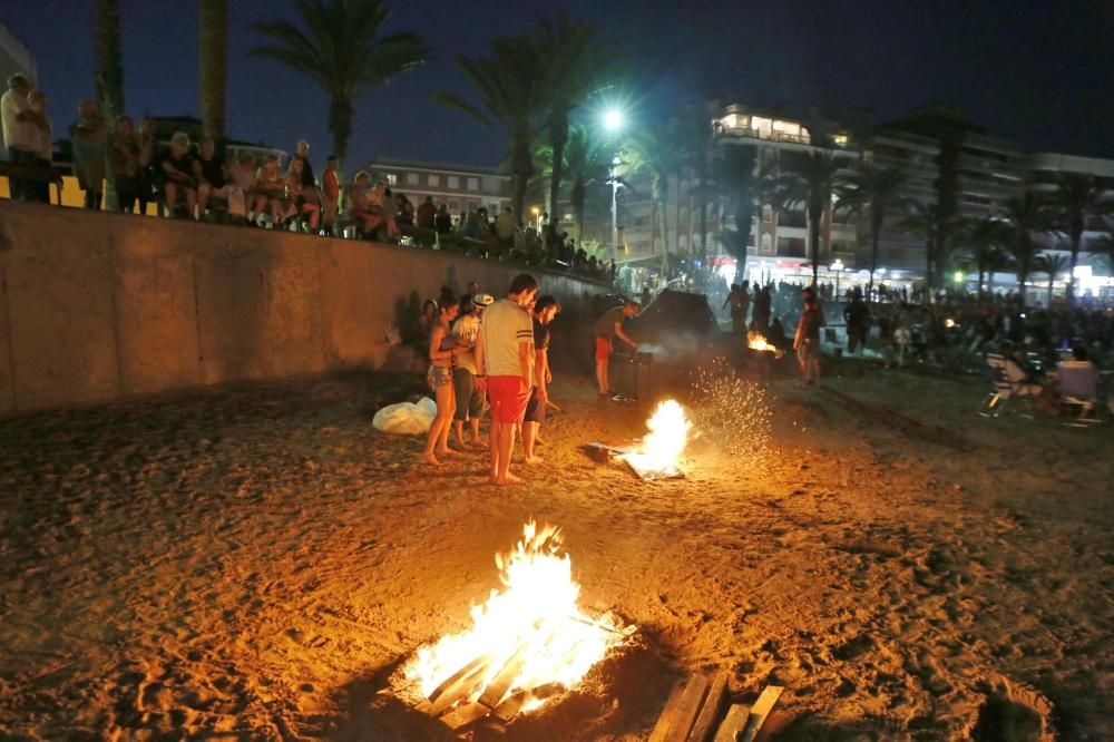 Noche de hogueras, baños, en las playas de la Vega Baja. En las imágenes grupos de amigos y familias en la playa del Cura de Torrevieja