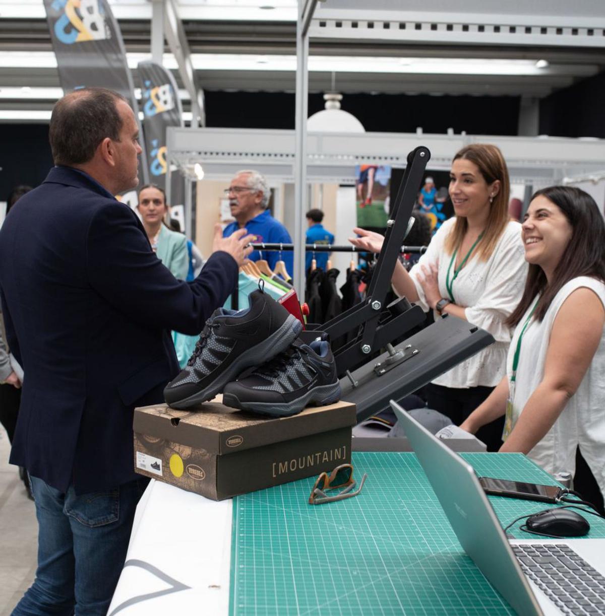 El presidente de la Diputación charla con dos jóvenes de un stand. | A. B.