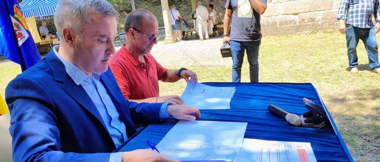 El alcalde de A Cañiza, Luis Piña, firma un convenio con el de Melón, Emilio Díaz. // D.P.