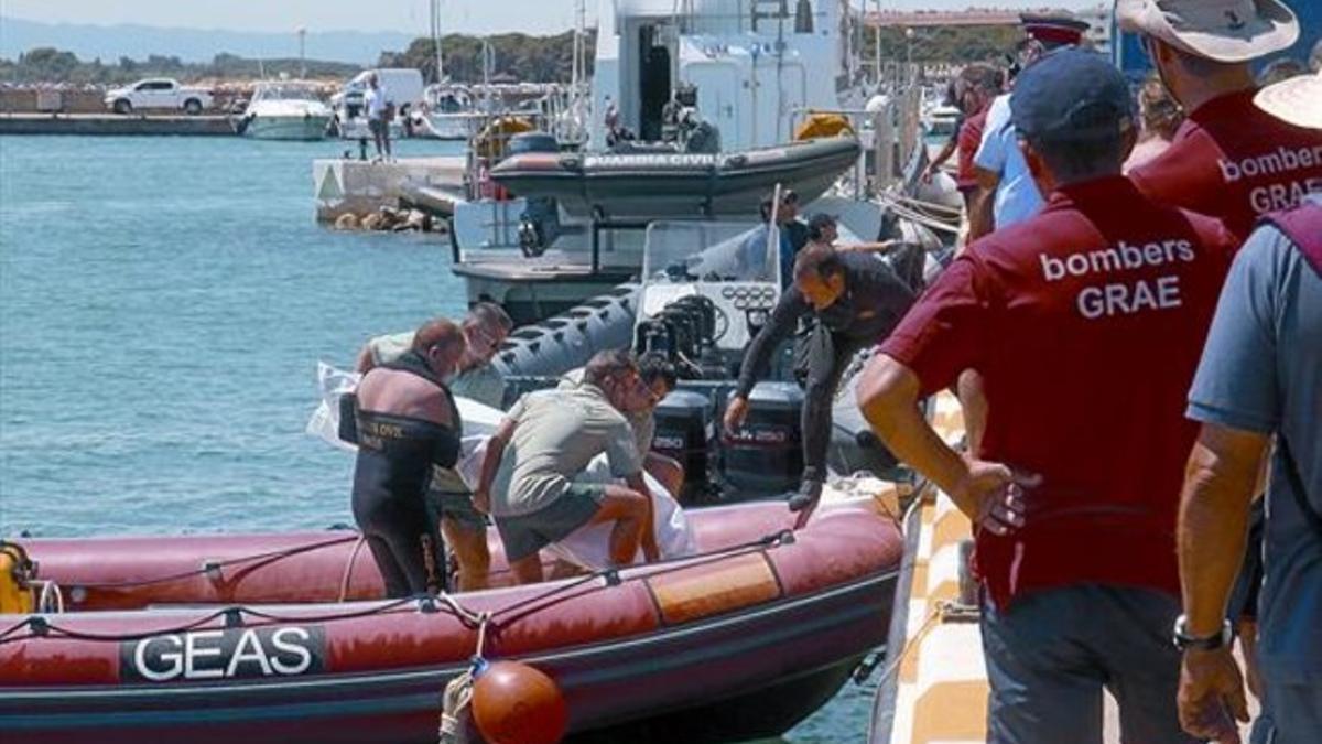 Un equipo de la Guardia Civil desembarca en el puerto de L'Estartit el cadáver del buceador hallado ayer.