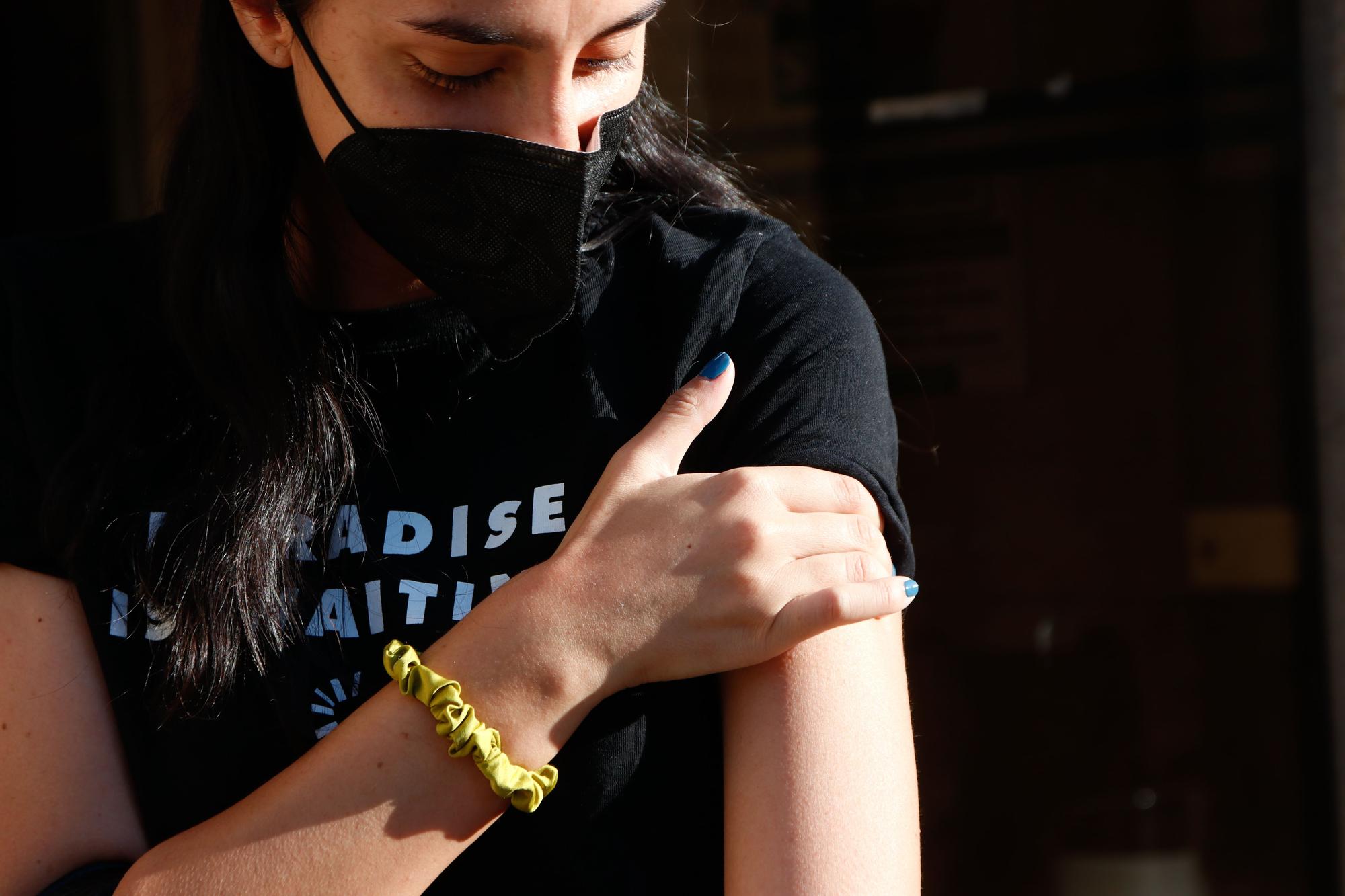 Una joven muestra su brazo después de haber recibido la tercera dosis.