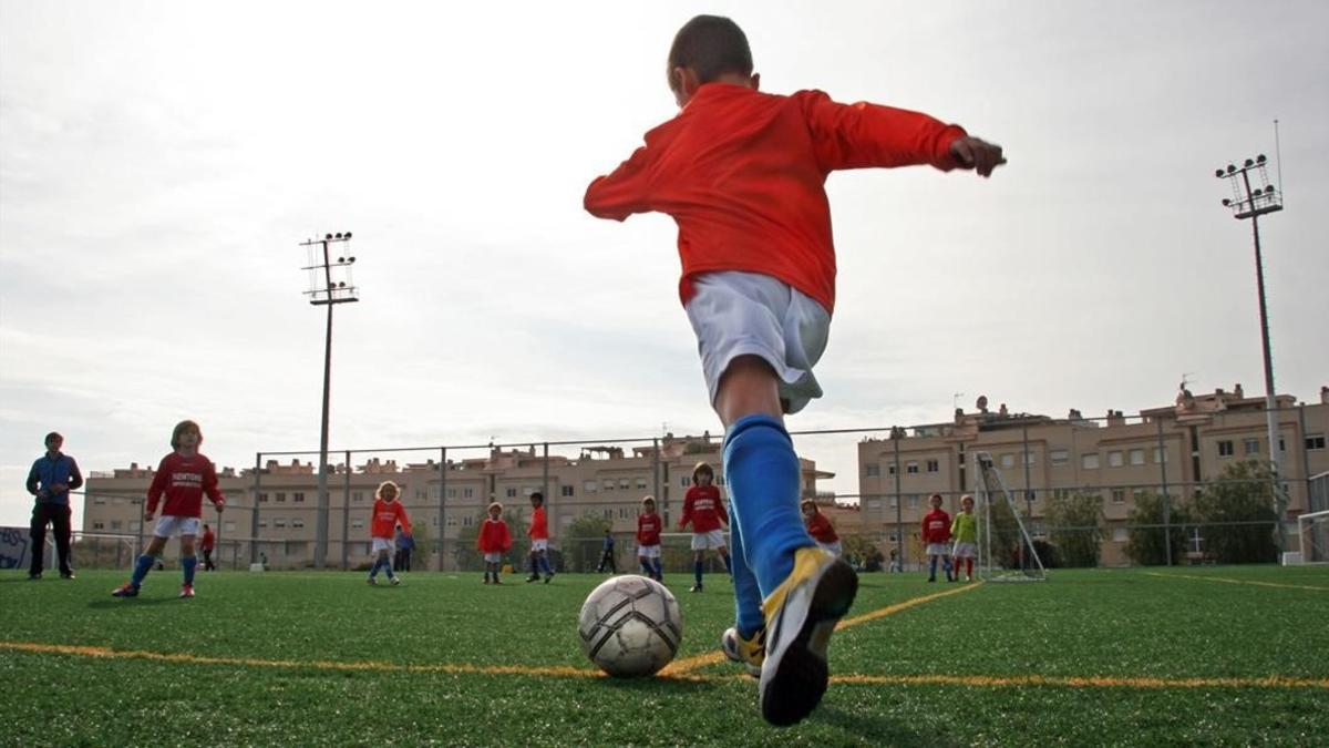 Un niño se apresta a chutar durante un partido de fútbol base.