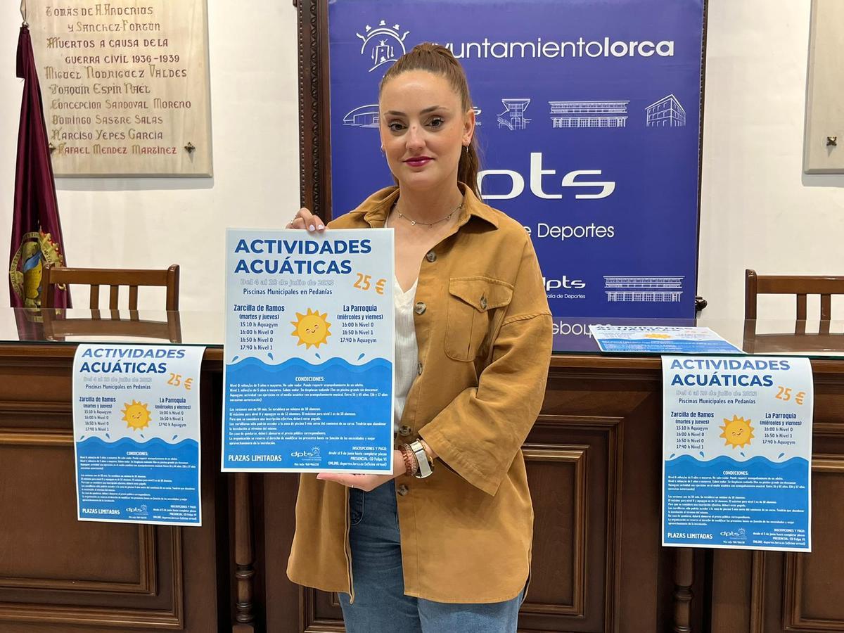 La edil en funciones de Deportes, Irene Jódar Pérez, con el cartel de las actividades acuáticas para este verano.