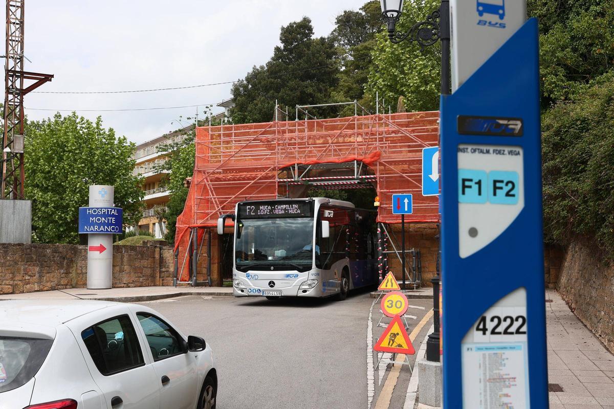 Un autobús circula bajo el arco de acceso al Hospital Monte Naranco.