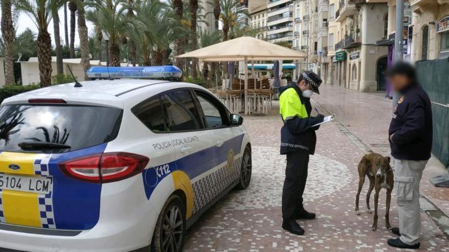 Un policía local de Alicante con un ciudadano que paseaba a su perro por la Explanada.