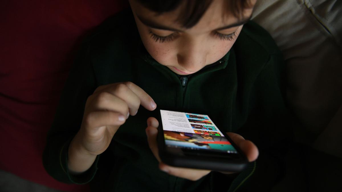 Un niño utiliza una aplicación de Youtube en un teléfono móvil.
