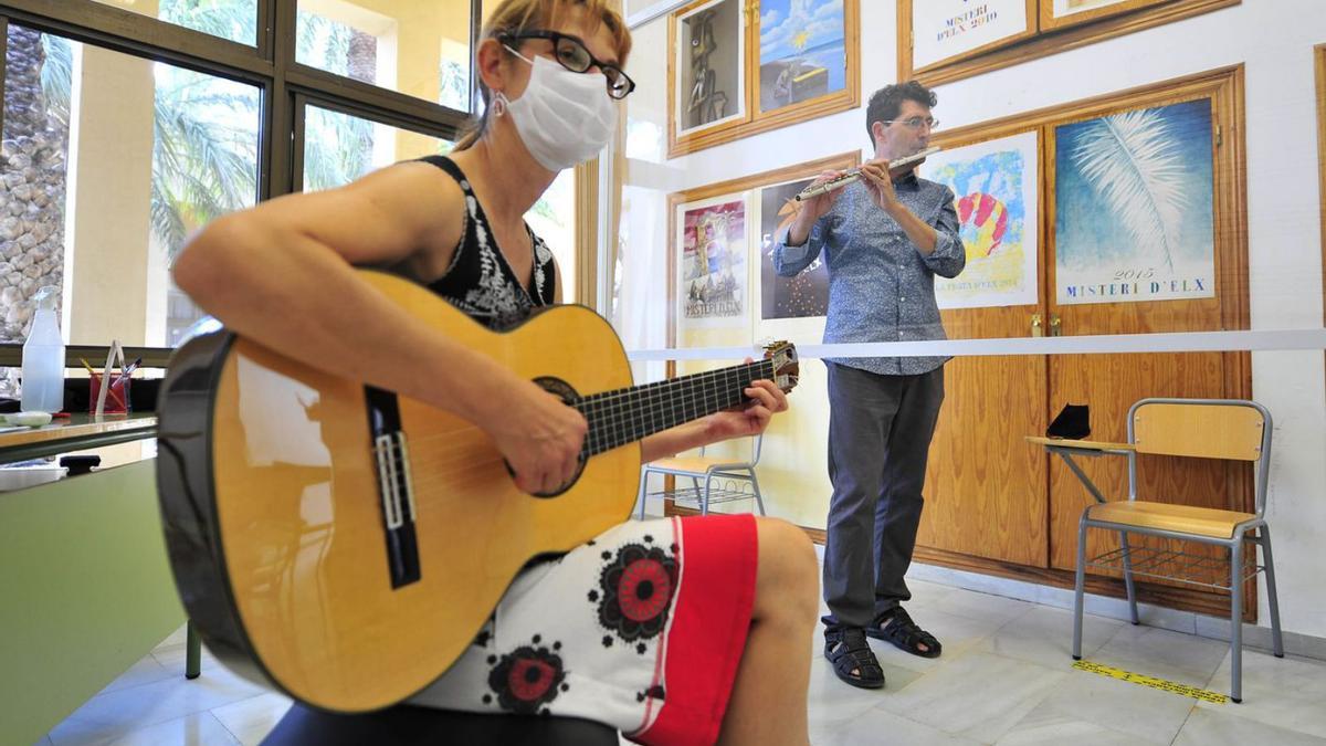 Una intérprete de guitarra y otro de flauta, en una de las aulas. | MATÍAS SEGARRA