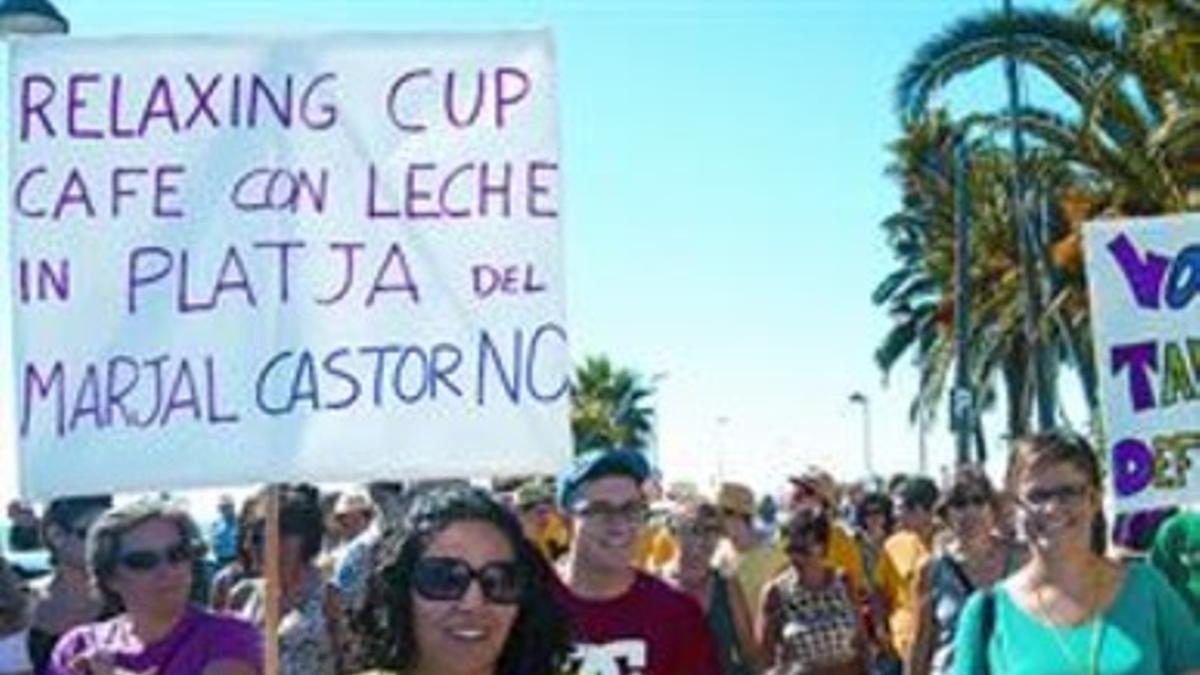 Manifestantes con pitos y pancartas durante la movilización.