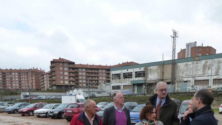 Miembros de la Corporación y técnicos municipales, ayer, en el aparcamiento, lleno de barro y charcos.