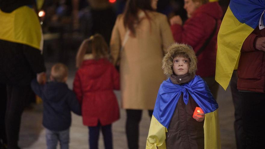 Un niño sostiene una vela en la manifestación por el primer aniversario de la guerra, en Cartagena. | IVÁN J. URQUÍZAR