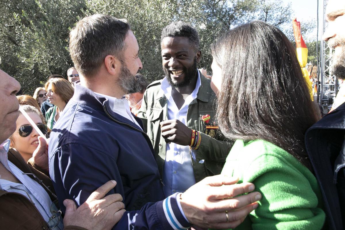 Ndongo saluda a Abascal en un acto de VOX en Madrid.
