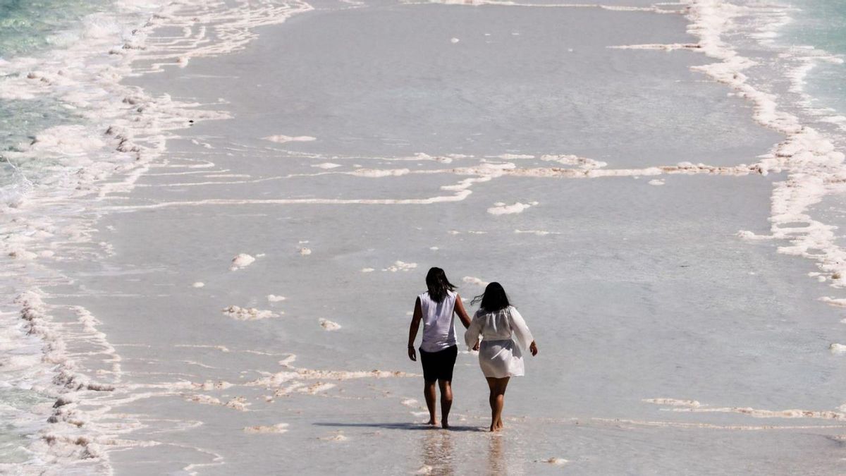 Dos turistes caminen en mig de formacions de sal, al mar Mort, a Israel. | ABIR SULTAN / EFE Dos turistes caminen en mig de formacions de sal, al mar Mort, a Israel. | ABIR SULTAN / EFE