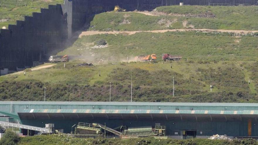 Camiones de carga transportan residuos en la planta de basuras de Nostián.