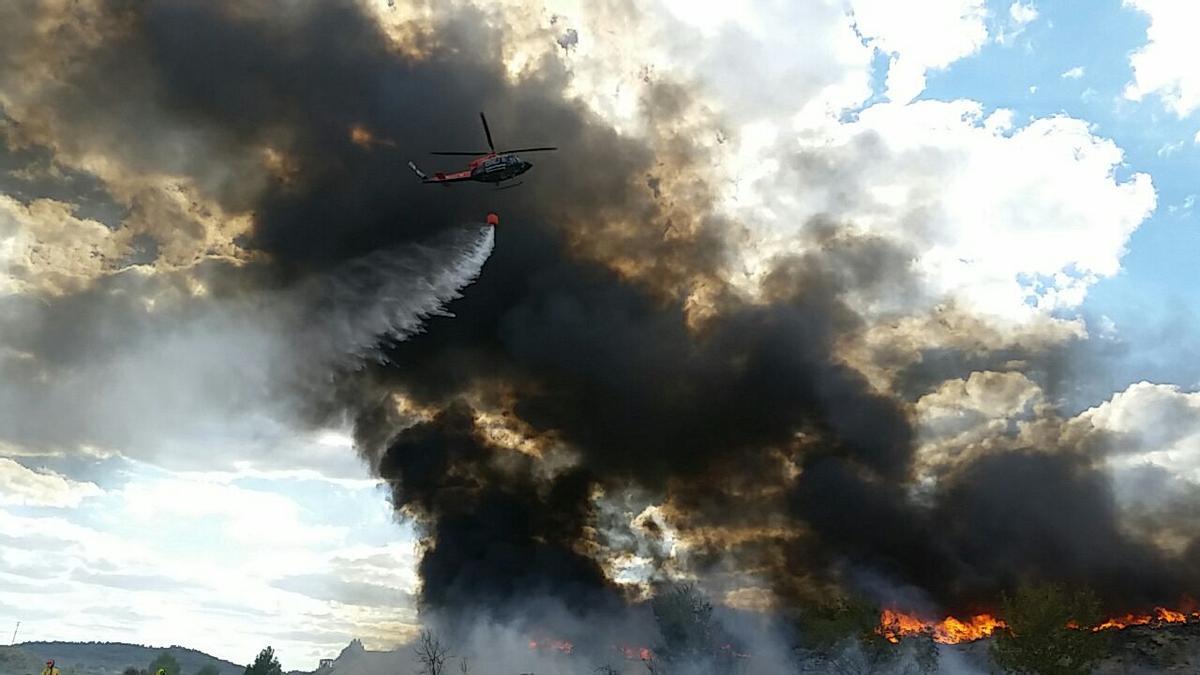 Un helicóptero descargando agua sobre el incendio.