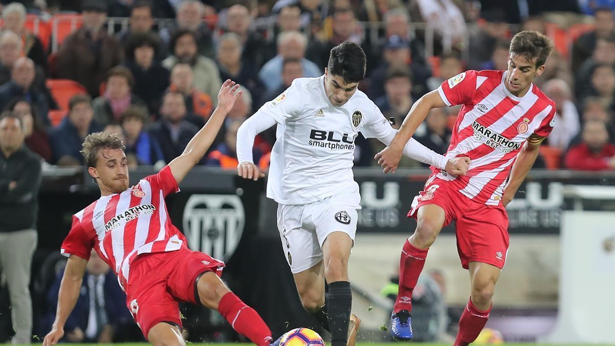 Carlos Soler intenta llevarse un balón en el último Valencia - Girona