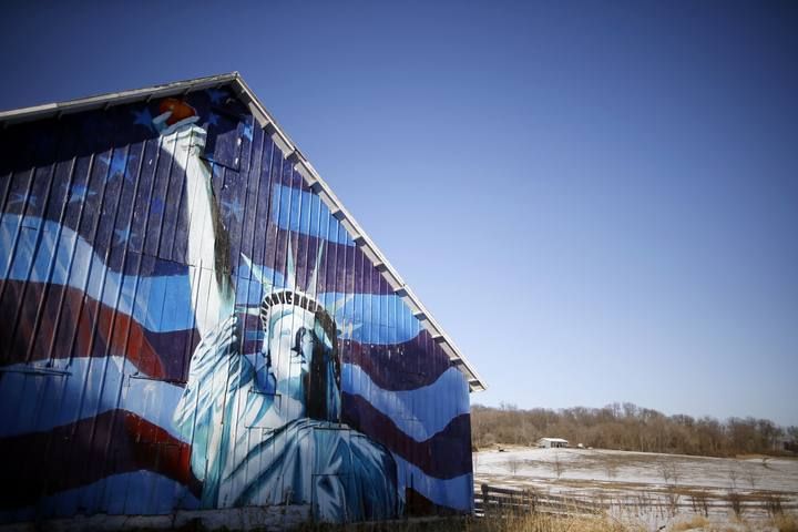 Un granero pintado con una imagen de la Estatua de la Libertad y una bandera estadounidense