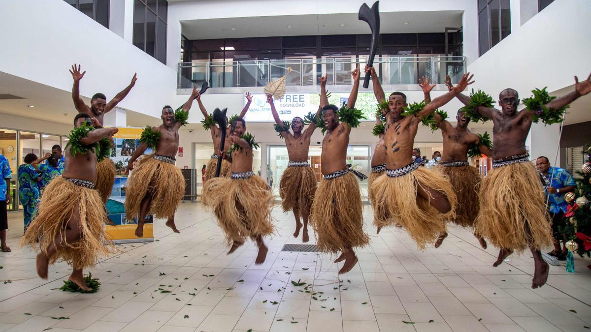 Un grupo de bailarines tradicionales de Fiyi dan la bienvenida a los primeros viajeros que llegan a las islas desde que arrancó la pandemia.