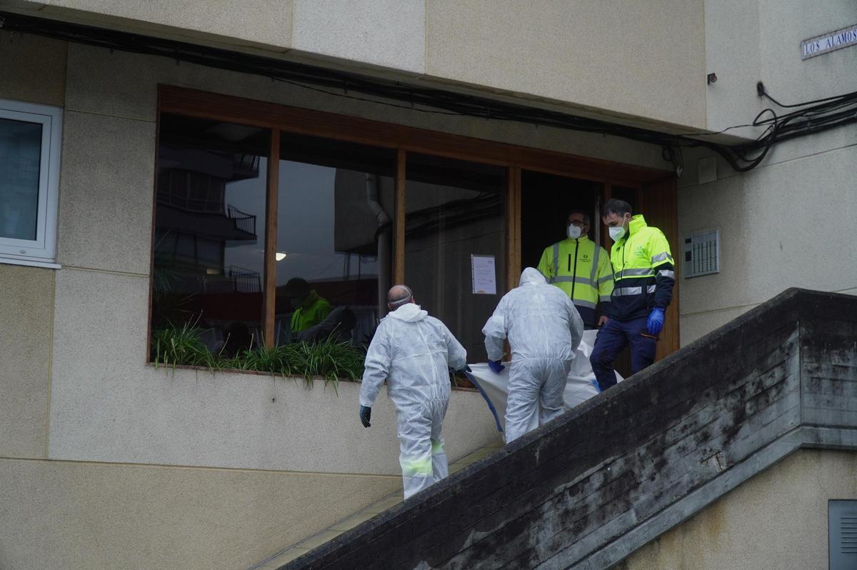 Los operarios retiran residuos del inmueble donde apareció el cadáver de un varón