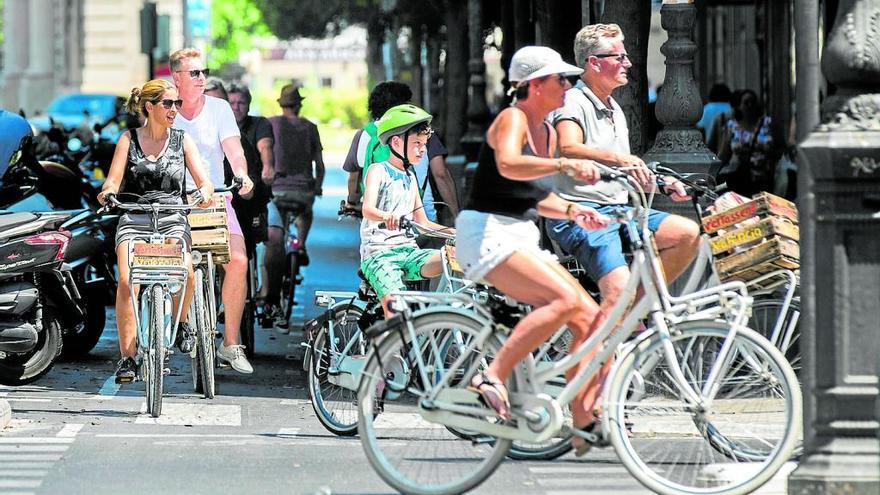 Usuarios de bicicleta pedalean por un carril bici.