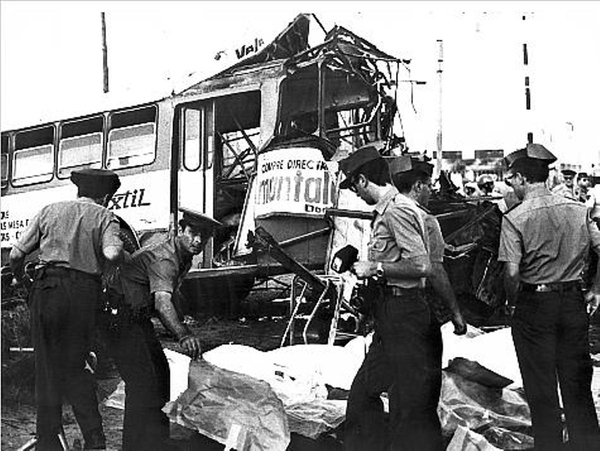 Miembros de la Guardia Civil junto a las víctimas y al autobús convertido en un amasijo de hierro.