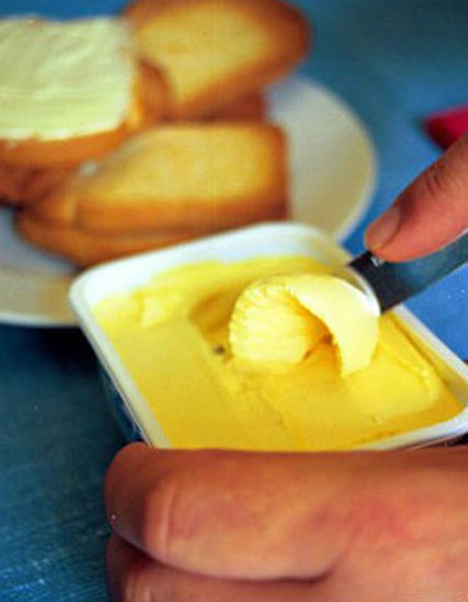 Una persona es prepara una torrada amb mantega.