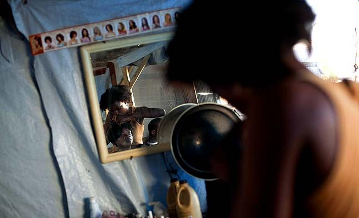 Julie Colin pentina una clienta al seu saló de bellesa al campament de Petionville Club a Port-au-Prince (Haití). Colin, que havia treballat en un saló de bellesa abans del terratrèmol, va obrir la seva pròpia tenda al campament i ha dit que el negoci és estable.