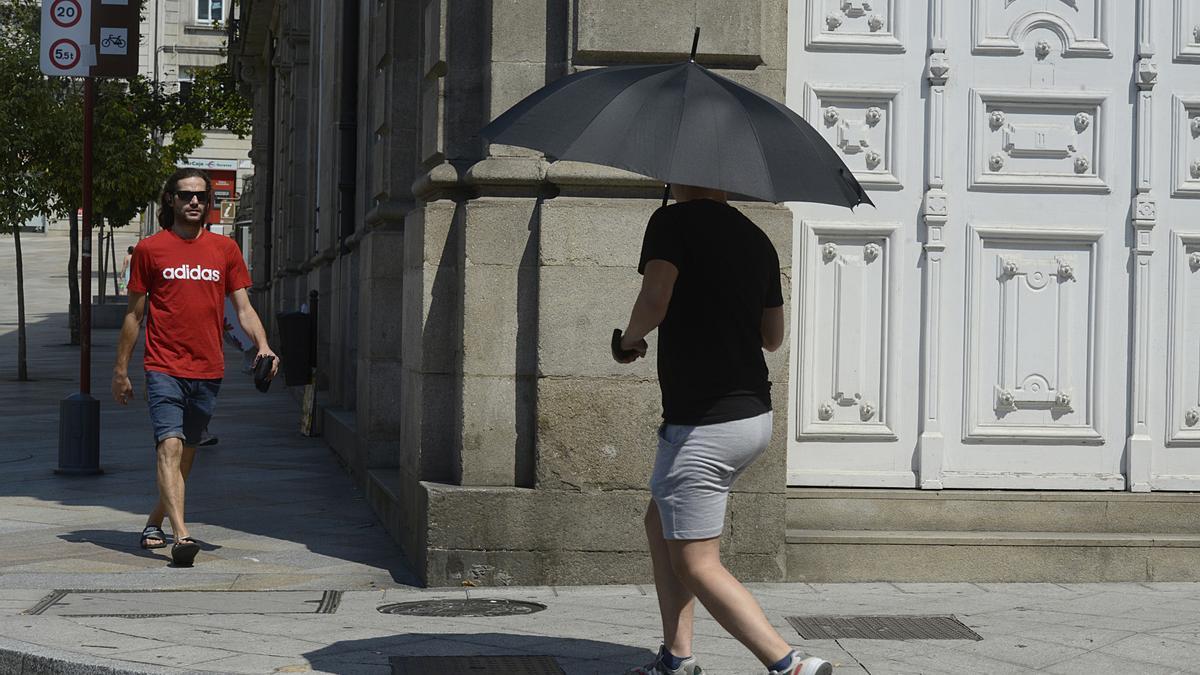 Archivo - Dos personas caminan por una vía en plena ola de calor, a 12 de julio de 2022, en Orense, Galicia (España). Los termómetros de la práctica totalidad del territorio gallego alcanzarán valores “extremos” debido a la ola de calor que comenzó la sem