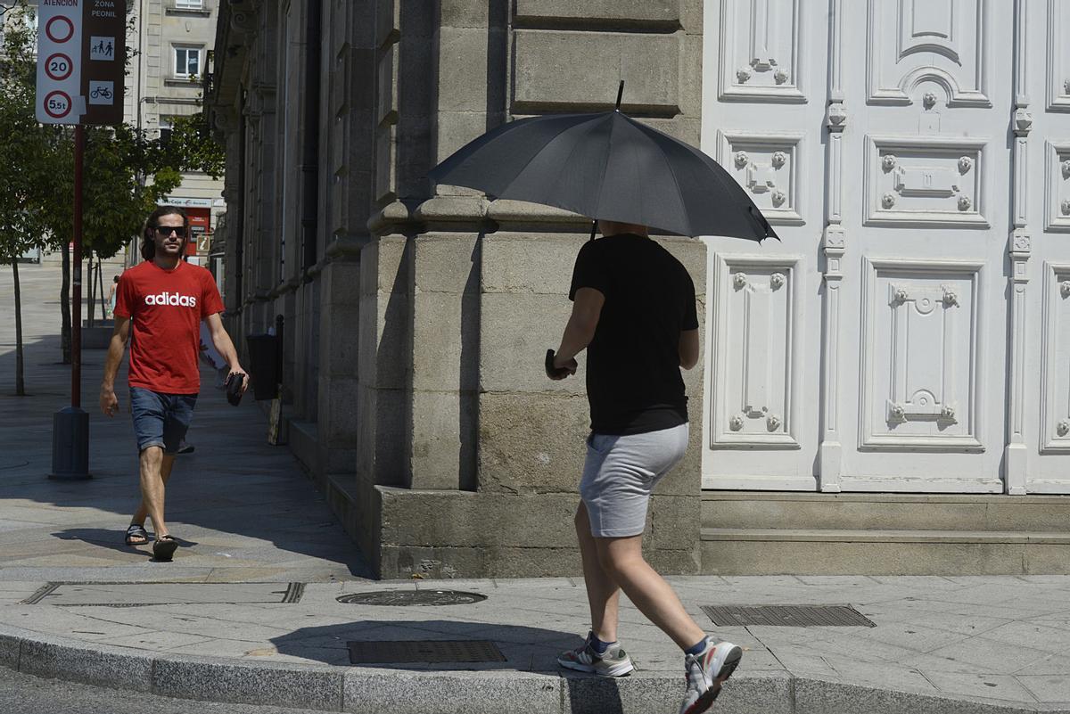 Archivo - Dos personas caminan por una vía en plena ola de calor, a 12 de julio de 2022, en Orense, Galicia (España). Los termómetros de la práctica totalidad del territorio gallego alcanzarán valores “extremos” debido a la ola de calor que comenzó la sem