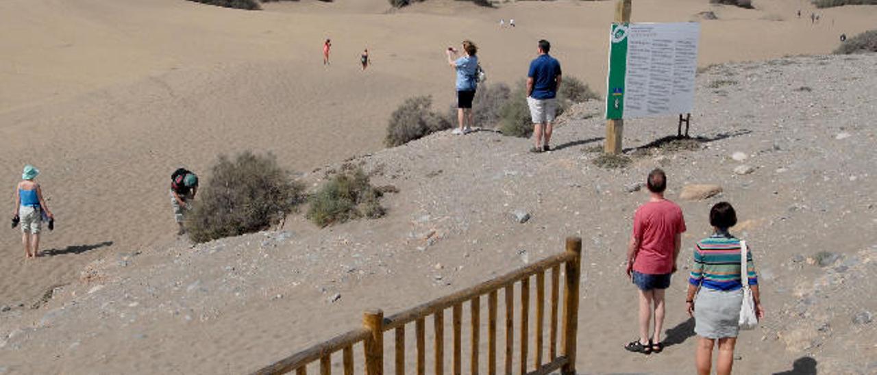 Turistas en uno de los accesos peatonales a las Dunas de Maspalomas.