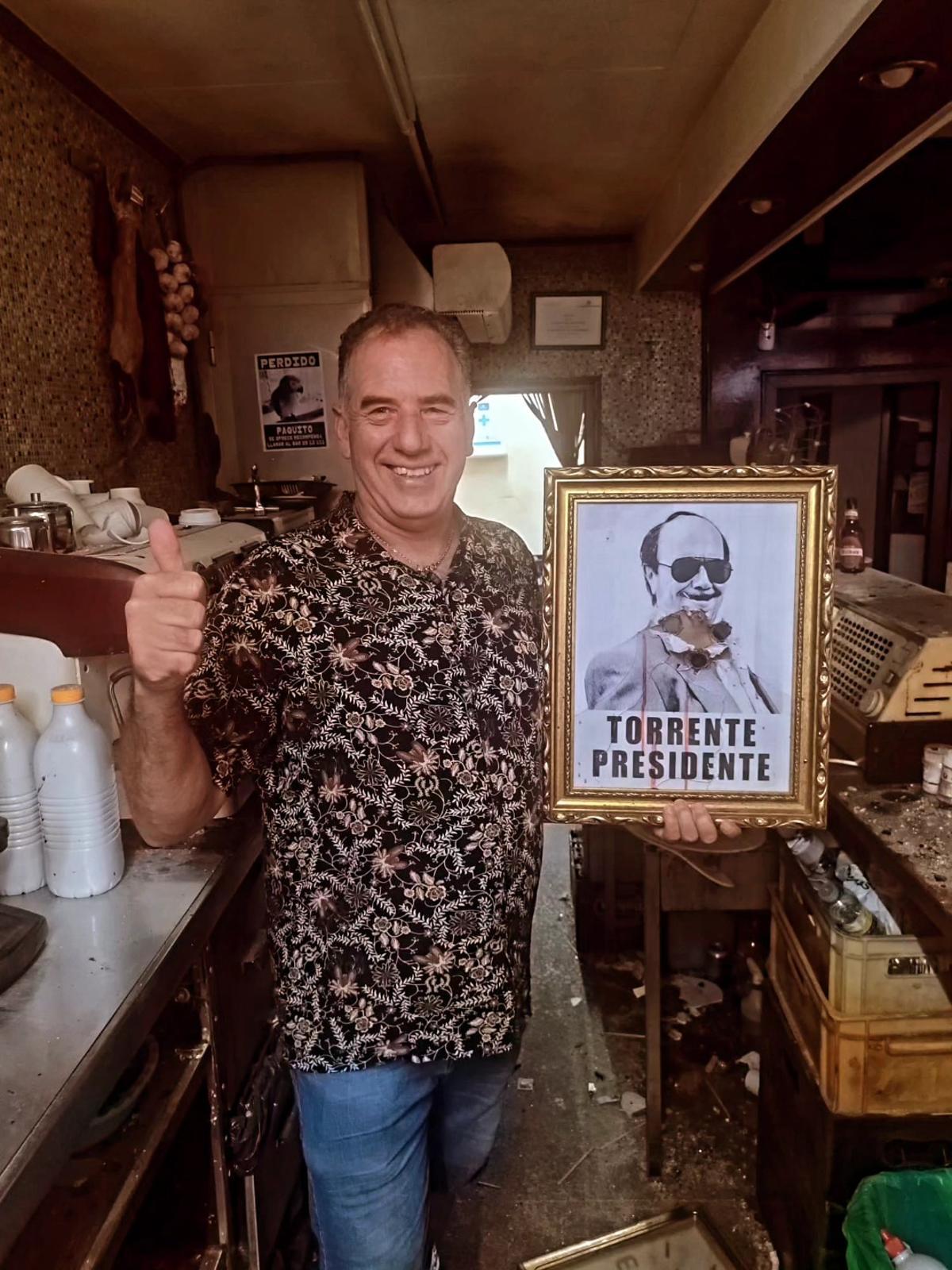 Benito, dueño del Bar Benito junto al cartel de 'Torrente, Presidente'