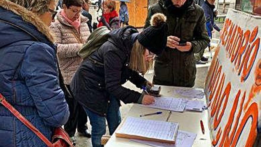 Una joven firma la petición.