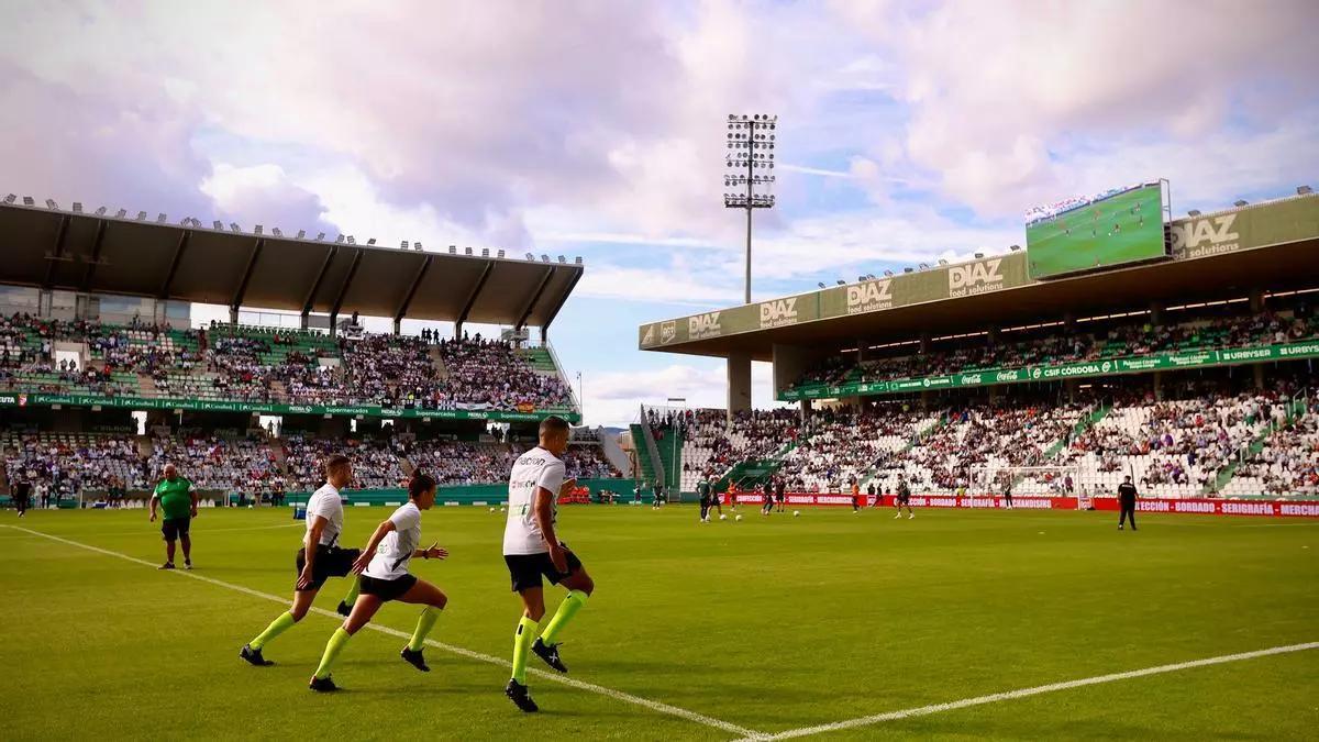 El trío arbitral del Córdoba CF-Ceuta calienta en El Arcángel, con uno de los nuevos videomarcadores de fondo, en noviembre.