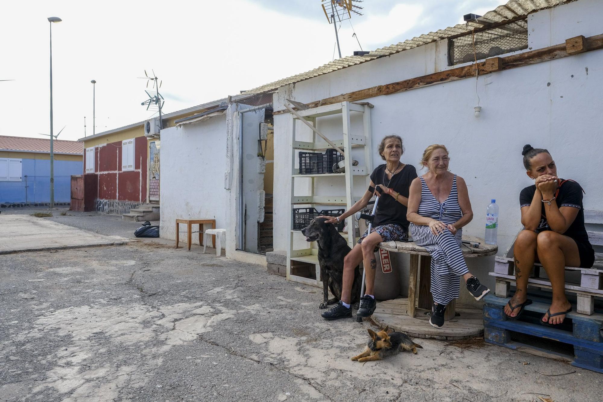 Soraya Pérez, Esther López y Daria Lemes conversan sentadas al aire libre en el centro del barrio.