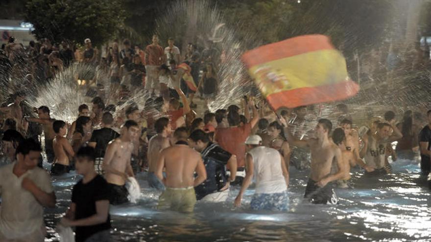 La afición de Santa Cruz de Tenerife celebra el triunfo de la Roja con un baño en el lago de la Plaza de España.