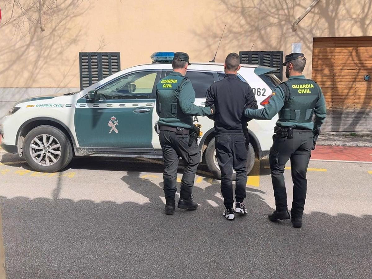 Agentes de la Guardia Civil custodian a uno de los detenidos.